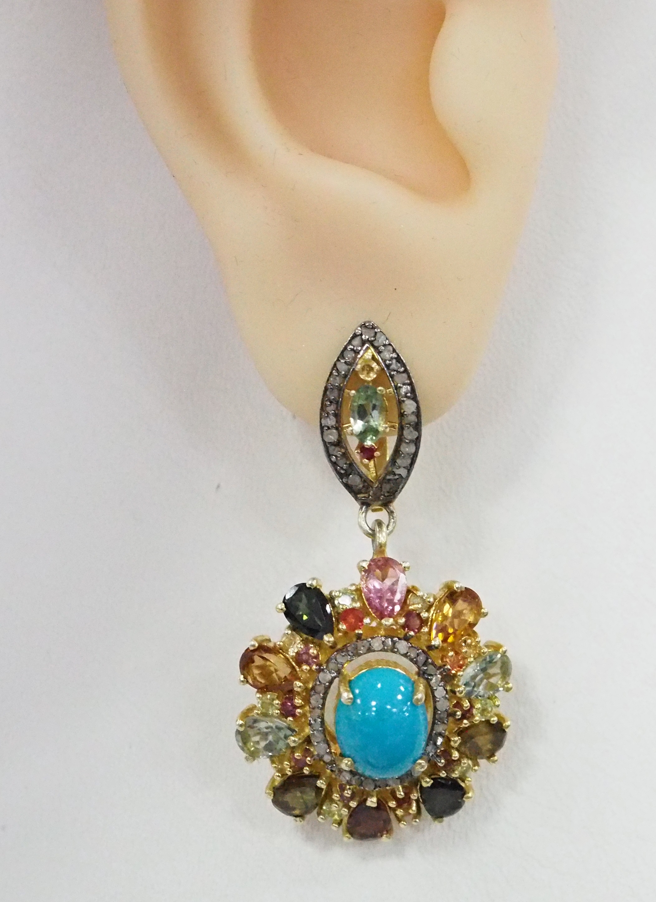 Серебряные серьги 925 пробы; вставки 2 Бирюза 5,04; 20 Турмалин цв.7,08; 2 Сапфир зел.0,6; 124 Бр.НВО 0,59 6/8; 2 Аметист 0,02; 14 Родолит 0,68; 2 Руб